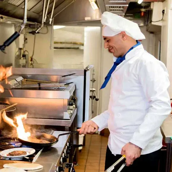 Wilshire Estates Chef Created Meals, chef frying a dish.