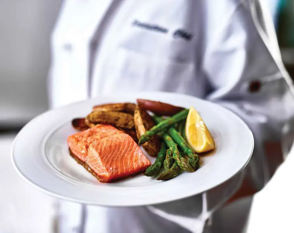 Wilshire Estates Chef Created Meals, chef delivering a finished dish.